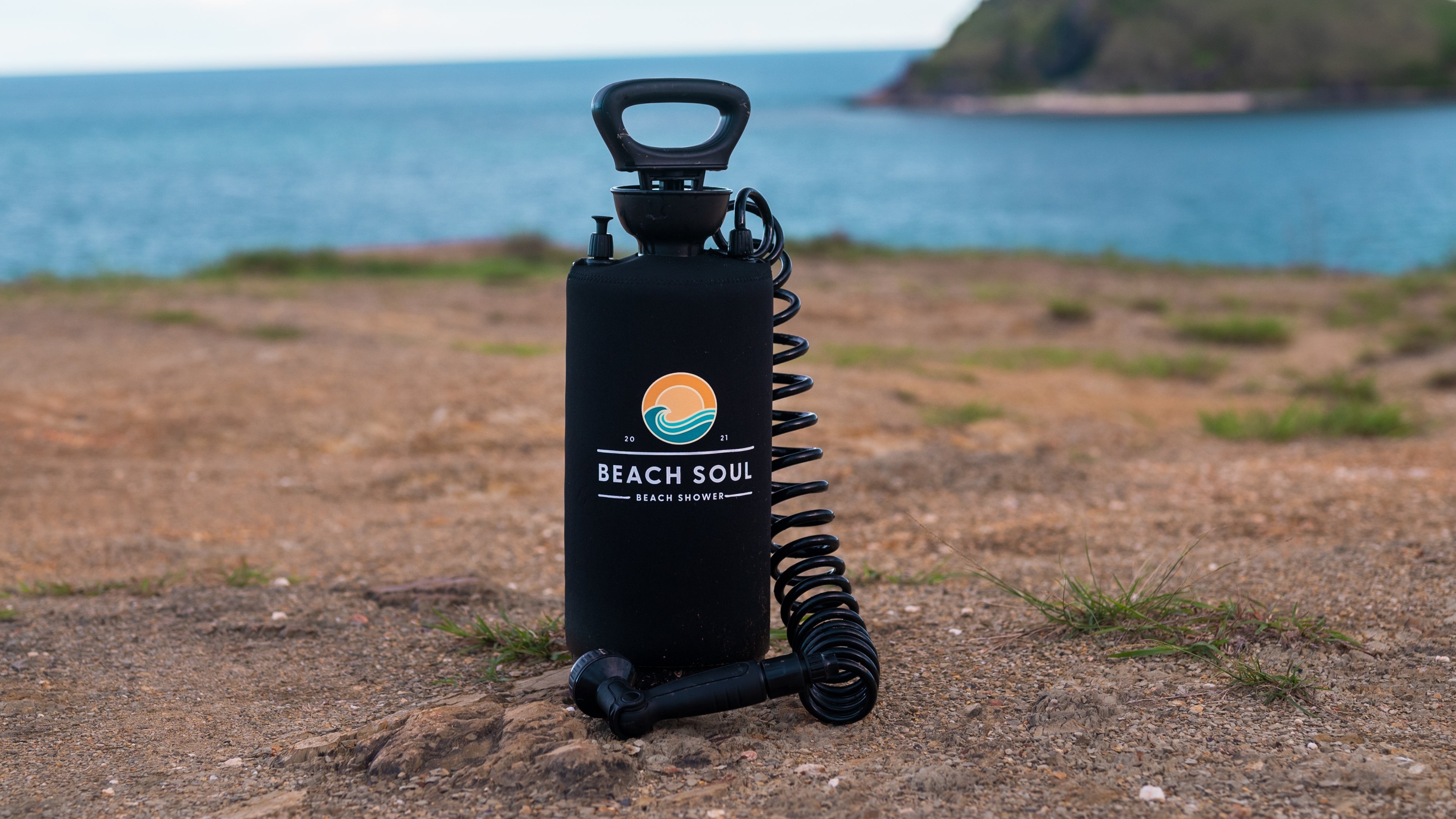 Beach Soul portable shower standing beside the coast