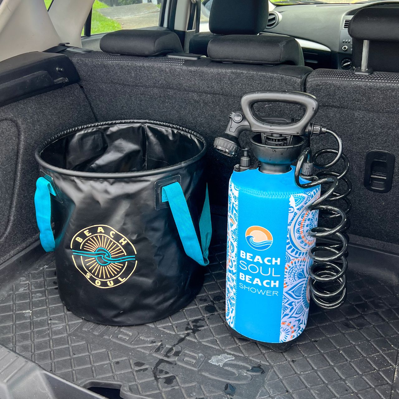 Beach Soul portable shower and Beach Soul Bag 'n' Mat stored together in a car boot