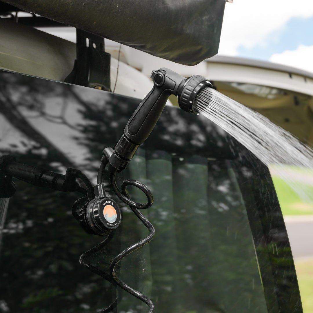 Beach Soul Portable Shower Holder mounted beneath an open vehicle boot and holding the shower head