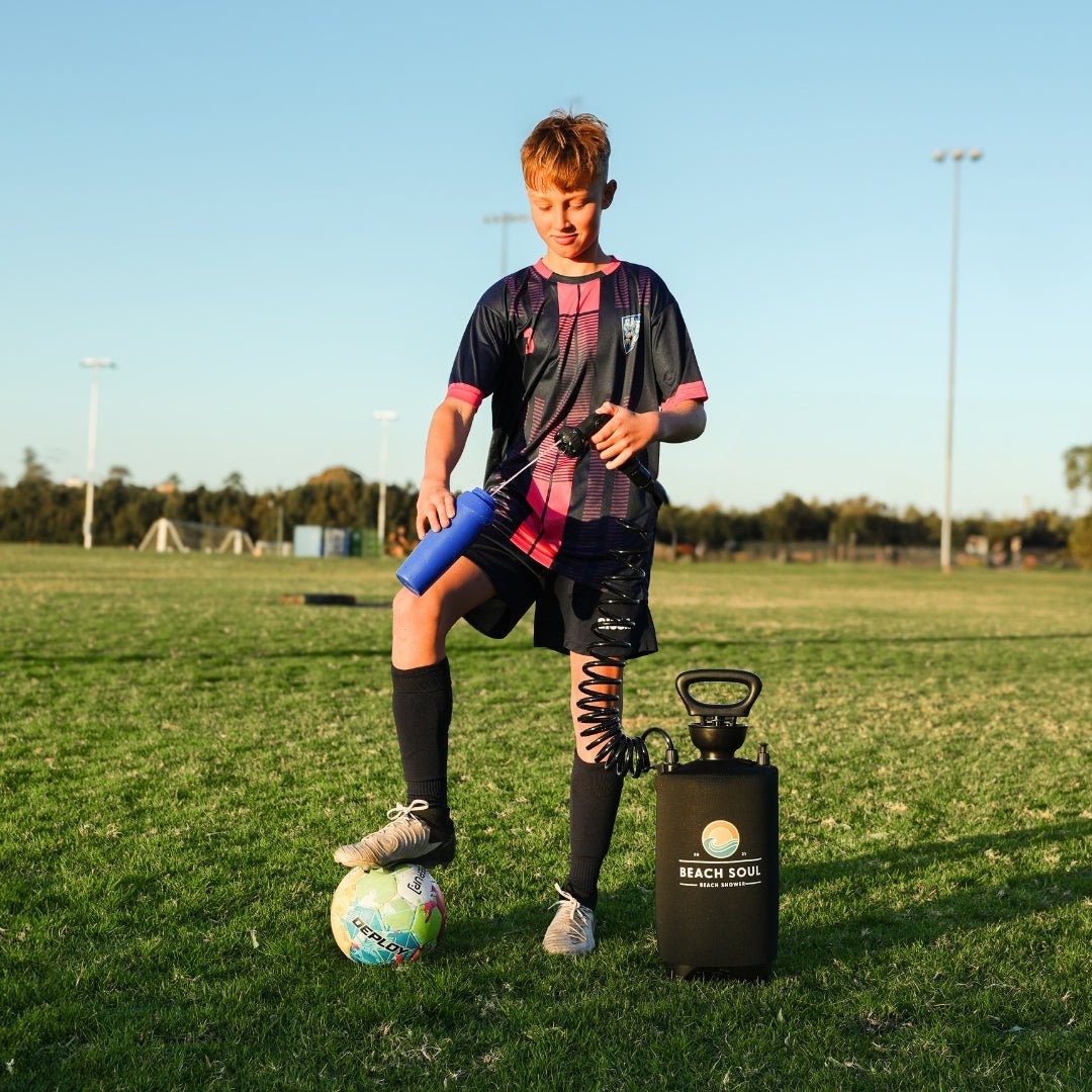 Boy filling up his water bottle water from the drink-safe PRO Bliss Out 10L portable shower after sport